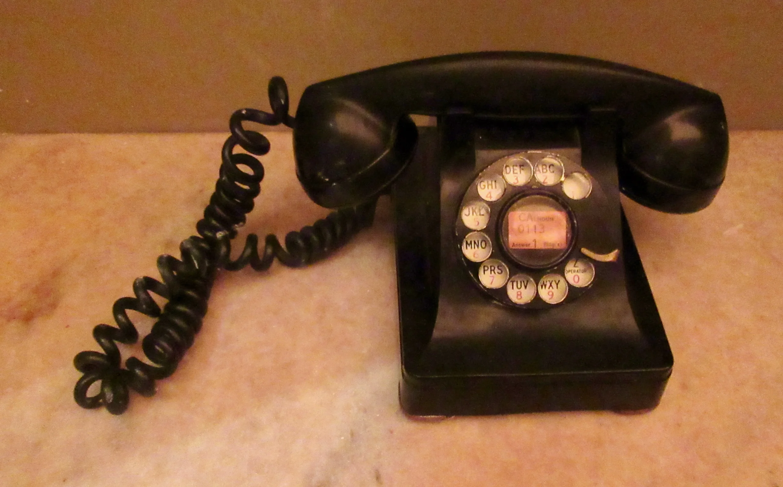 Vintage rotary dial telephone in a street-side window display, classic analog communication device